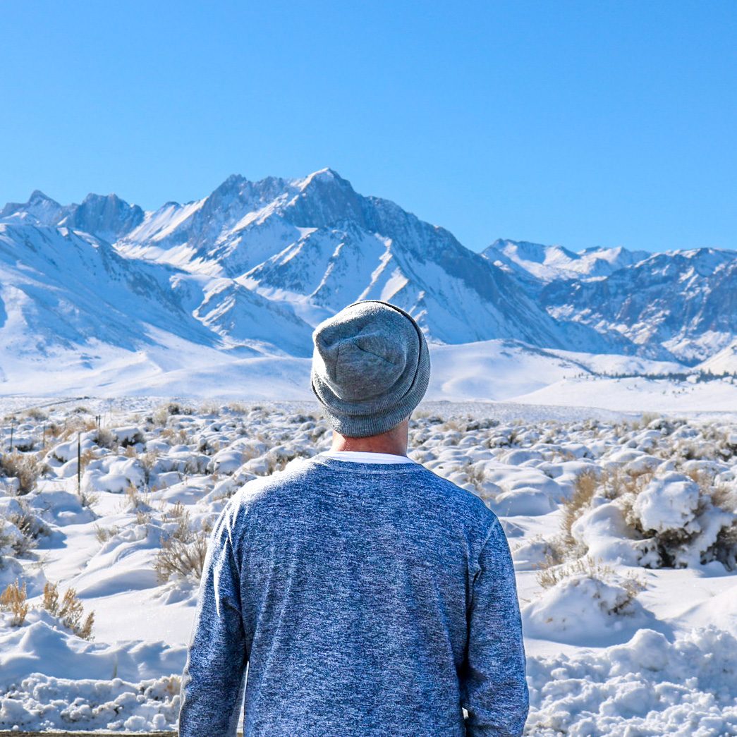 Alec Snow facing a snow-covered mountain landscape
